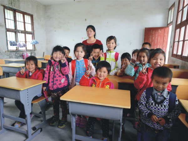 公司為一山村小學捐贈一批課桌椅，孩子們高興地和老師一起合影